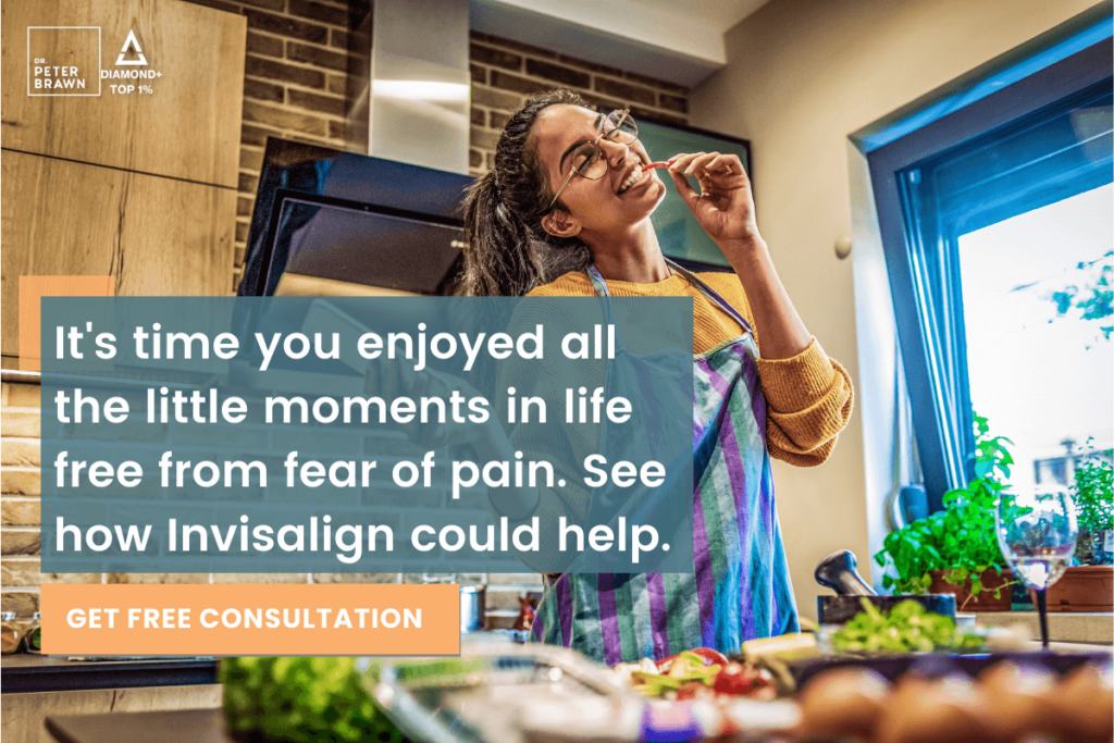 Woman enjoying a straighter smile and TMJ pain relief while eating in the kitchen